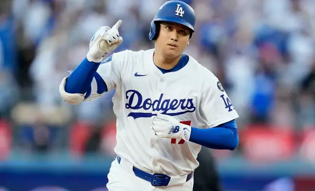 Los Angeles Dodgers' Shohei Ohtani celebrates after a home run against the Milwaukee Brewers during the first inning in Game 4 of baseball's National League Championship Series, Friday, Oct. 17, 2025, in Los Angeles. (AP Photo/Ashley Landis)