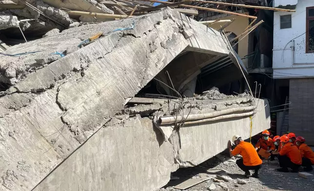 Rescuers search for victims after a building under construction collapsed, at an Islamic boarding school in Sidoarjo, East Java, Indonesia, Wednesday, Oct. 1, 2025. (AP Photo/Trisnadi)
