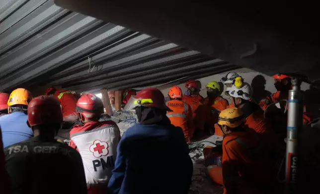 Rescuers search for victims after a building under construction collapsed, at an Islamic boarding school in Sidoarjo, East Java, Indonesia, Tuesday, Sept. 30, 2025. (AP Photo/Trisnadi)