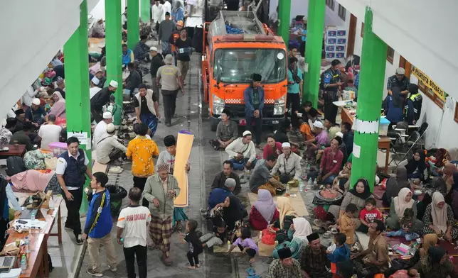 Family members of students wait in Sidoarjo, East Java, Indonesia, Wednesday, Oct. 1, 2025, as rescue works are underway for victims trapped under the rubble after a building under construction collapsed at an Islamic boarding school. (AP Photo/Achmad Ibrahim)