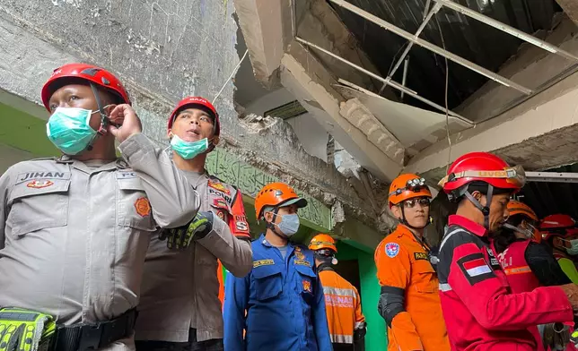 Rescuers search for victims trapped under the rubble after a building under construction collapsed, at an Islamic boarding school in Sidoarjo, East Java, Indonesia, Wednesday, Oct. 1, 2025. (AP Photo/Trisnadi)