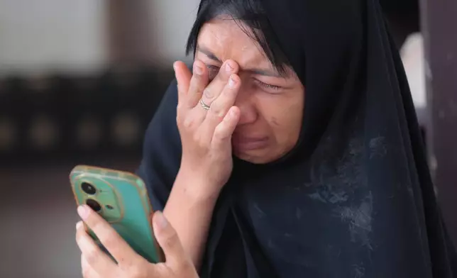 A woman weeps as rescue works are underway for victims trapped under the rubble after a building under construction collapsed at an Islamic boarding school in Sidoarjo, East Java, Indonesia, Wednesday, Oct. 1, 2025. (AP Photo/Trisnadi)