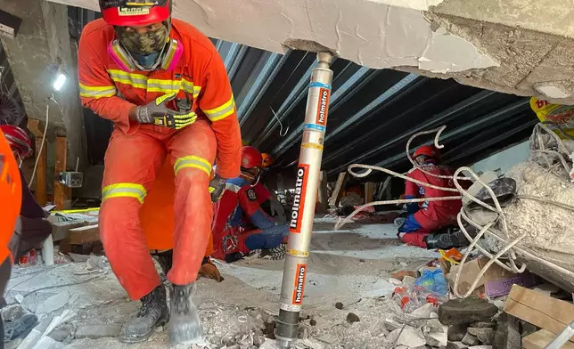 Rescuers search for victims trapped under the rubble after a building under construction collapsed, at an Islamic boarding school in Sidoarjo, East Java, Indonesia, Wednesday, Oct. 1, 2025. (AP Photo/Trisnadi)