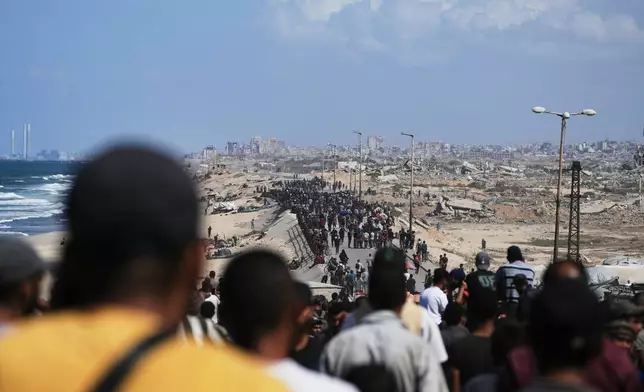 Displaced Palestinians walk along the coastal road near Wadi Gaza in the central Gaza Strip, moving toward northern Gaza, Friday, Oct. 10, 2025, after Israel and Hamas have agreed to a pause in their war and the release of the remaining hostages. (AP Photo/Abdel Kareem Hana)