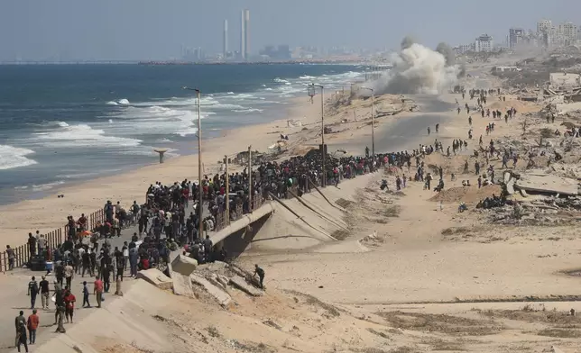 Displaced Palestinians walk along the coastal road near Wadi Gaza in the central Gaza Strip, moving toward northern Gaza, Friday, Oct. 10, 2025, after Israel and Hamas have agreed to a pause in their war and the release of the remaining hostages. (AP Photo/Yousef Al Zanoun)