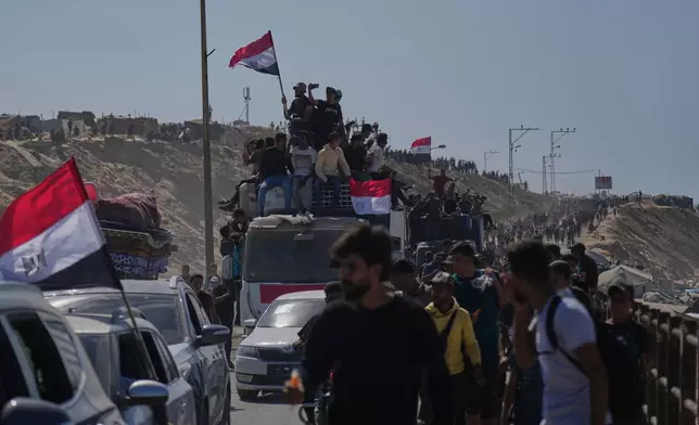 Displaced Palestinians ride on vehicles and wave Egyptian flags as they move along the coastal road near Wadi Gaza in the central Gaza Strip, heading toward Gaza City, Friday, Oct. 10, 2025, after Israel and Hamas agreed to a pause in their war and the release of the remaining hostages. (AP Photo/Abdel Kareem Hana)