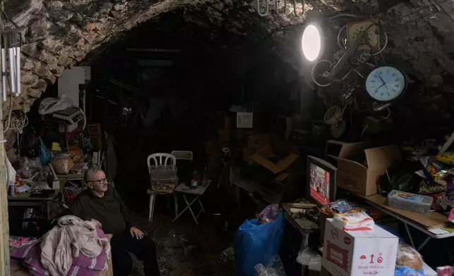 A street vendor watches the news on television after the announcement that Israel and Hamas have agreed to the first phase of a peace plan to pause the fighting, as he sits in his shop, in the Old City of Nablus, in the West Bank, Thursday, Oct. 9, 2025. (AP Photo/Majdi Mohammed)