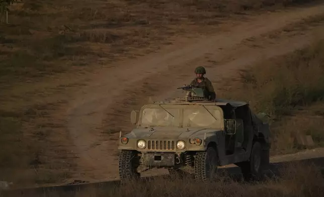Israeli soldiers move near the Israeli-Gaza border, as seen from southern Israel, Thursday, Oct. 9, 2025, following the announcement that Israel and Hamas have agreed to the first phase of a peace plan to pause the fighting. (AP Photo/Ariel Schalit)