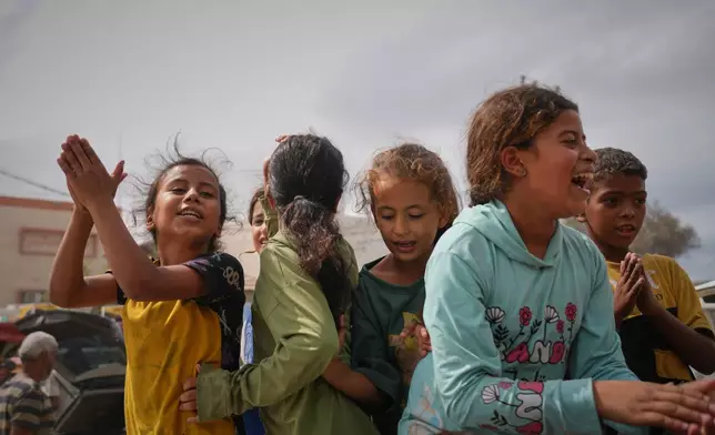 Palestinians celebrate following the announcement that Israel and Hamas have agreed to the first phase of a peace plan to pause the fighting, in Khan Younis, southern Gaza Strip, Thursday, Oct. 9, 2025. (AP Photo/Jehad Alshrafi)