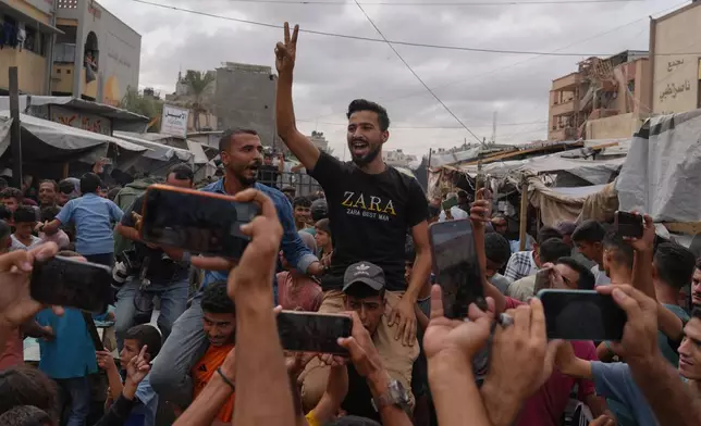 Palestinians celebrate following the announcement that Israel and Hamas have agreed to the first phase of a peace plan to pause the fighting, in Khan Younis, southern Gaza Strip, Thursday, Oct. 9, 2025. (AP Photo/Jehad Alshrafi)