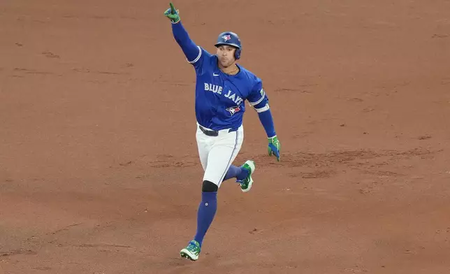 Toronto Blue Jays' George Springer rounds the bases after hitting a solo home run against the Seattle Mariners during the first inning in Game 1 of baseball's American League Championship Series in Toronto, Sunday, Oct. 12, 2025. (Chris Young/The Canadian Press via AP)