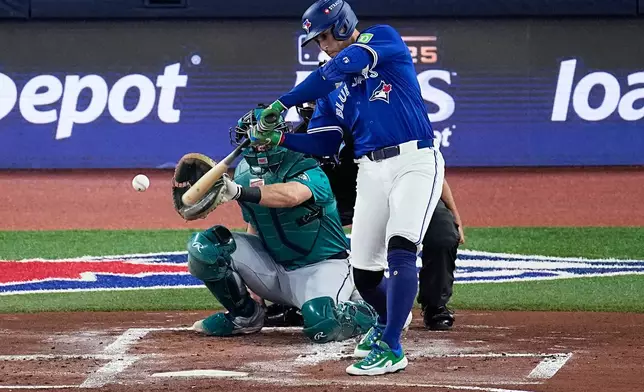 Toronto Blue Jays George Springer connects for a solo home run against the Seattle Mariners during the first inning in Game 1 of baseball's American League Championship Series, Sunday, Oct. 12, 2025, in Toronto. (AP Photo/David J. Phillip)