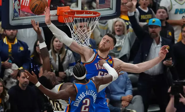Indiana Pacers' Bennedict Mathurin (00) puts up a shot against Oklahoma City Thunder's Shai Gilgeous-Alexander (2) and Isaiah Hartenstein (55) during overtime of an NBA basketball game, Thursday, Oct. 23, 2025, in Indianapolis. (AP Photo/Darron Cummings)