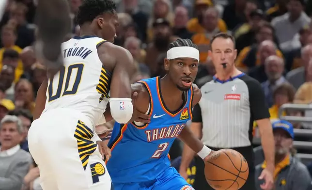 Oklahoma City Thunder's Shai Gilgeous-Alexander (2) is defended by Indiana Pacers' Bennedict Mathurin (00) during the first half of an NBA basketball game, Thursday, Oct. 23, 2025, in Indianapolis. (AP Photo/Darron Cummings)