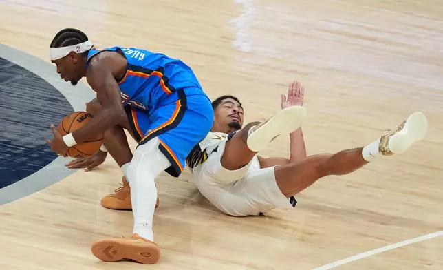 Oklahoma City Thunder's Shai Gilgeous-Alexander and Indiana Pacers' Ben Sheppard battle for a loose ball during the second overtime of an NBA basketball game, Thursday, Oct. 23, 2025, in Indianapolis. (AP Photo/Darron Cummings)