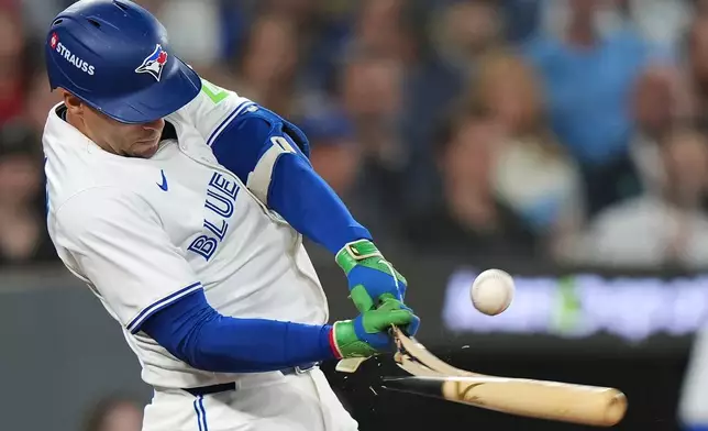 Toronto Blue Jays' George Springer breaks his bat on pop flyout to foul territory during the first inning of Game 6 of baseball's American League Championship Series against the Seattle Mariners in Toronto, Sunday, Oct. 19, 2025. (Frank Gunn/The Canadian Press via AP)