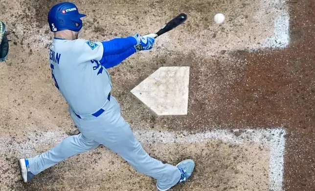 Los Angeles Dodgers' Freddie Freeman hits a double during the eighth inning of Game 1 of baseball's National League Championship Series against the Milwaukee Brewers Monday, Oct. 13, 2025, in Milwaukee. (AP Photo/Morry Gash)