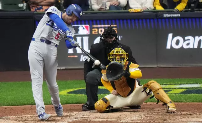 Los Angeles Dodgers' Freddie Freeman hits a double during the eighth inning of Game 1 of baseball's National League Championship Series against the Milwaukee Brewers Monday, Oct. 13, 2025, in Milwaukee. (AP Photo/Morry Gash)
