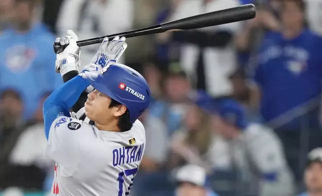 Los Angeles Dodgers' Shohei Ohtani (17) hits a two-run home run against the Toronto Blue Jays during the sixth inning in Game 1 of baseball's World Series, Friday, Oct. 24, 2025, in Toronto. (Nathan Denette/The Canadian Press via AP)