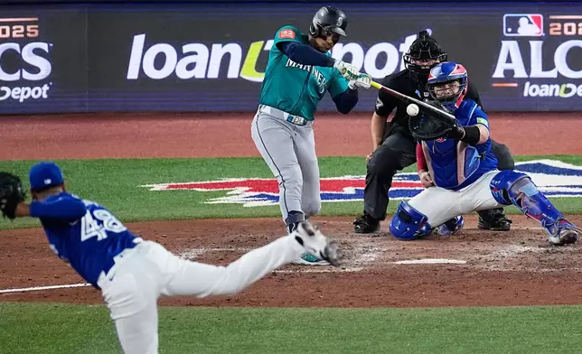 Seattle Mariners Jorge Polanco connects for an RBI single as Toronto Blue Jays pitcher Seranthony Domínguez (48) follows through during the eighth inning in Game 1 of baseball's American League Championship Series, Sunday, Oct. 12, 2025, in Toronto. (AP Photo/David J. Phillip)