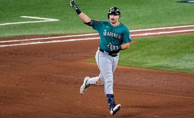 Seattle Mariners' Cal Raleigh celebrates his solo home run as he rounds the bases against the Toronto Blue Jays during the sixth inning in Game 1 of baseball's American League Championship Series, Sunday, Oct. 12, 2025, in Toronto. (AP Photo/David J. Phillip)