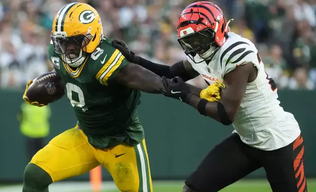 Green Bay Packers running back Josh Jacobs (8) runs against Cincinnati Bengals safety Jordan Battle (27) in the second half of an NFL football game, Sunday, Oct. 12, 2025, in Green Bay, Wis. (AP Photo/Morry Gash)