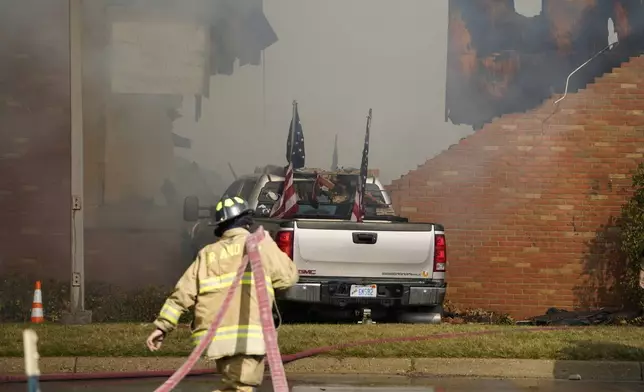 FILE - Firefighters work on the scene of a fire and shooting at the Church of Jesus Christ of Latter-day Saints in Grand Blanc, Mich., Sunday, Sept. 28, 2025. (Lukas Katilius/The Flint Journal via AP, File)
