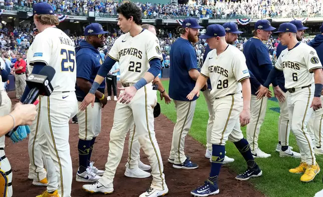 Milwaukee Brewers players high-five after defeating the Chicago Cubs 9-3 in Game 1 of baseball's National League Division Series, Saturday, Oct. 4, 2025, in Milwaukee. (AP Photo/Kayla Wolf)