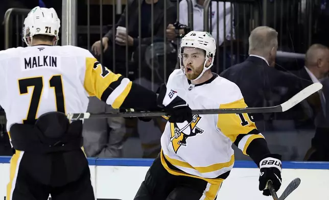 Pittsburgh Penguins right wing Justin Brazeau (16) is congratulated by Evgeni Malkin (71) after scoring a goal in the third period of an NHL hockey game against the New York Rangers, Tuesday, Oct. 7, 2025, in New York. (AP Photo/Adam Hunger)