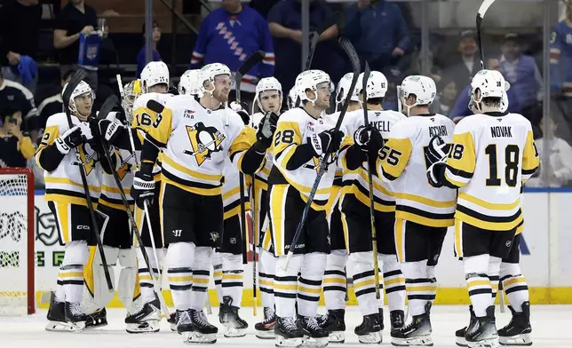 Pittsburgh Penguins defenseman Parker Wotherspoon (28) celebrates with teammates after defeating the New York Rangers in an NHL hockey game Tuesday, Oct. 7, 2025, in New York. (AP Photo/Adam Hunger)