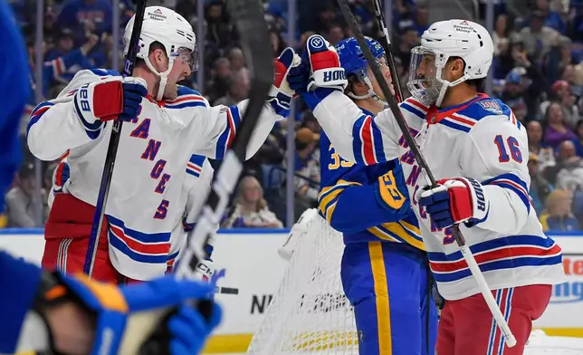 New York Rangers left wing Alexis Lafreniere, left, celebrates with center Vincent Trocheck (16) after scoring during the first period of an NHL hockey game against the Buffalo Sabres in Buffalo, N.Y., Thursday, Oct. 9, 2025. (AP Photo/Adrian Kraus)