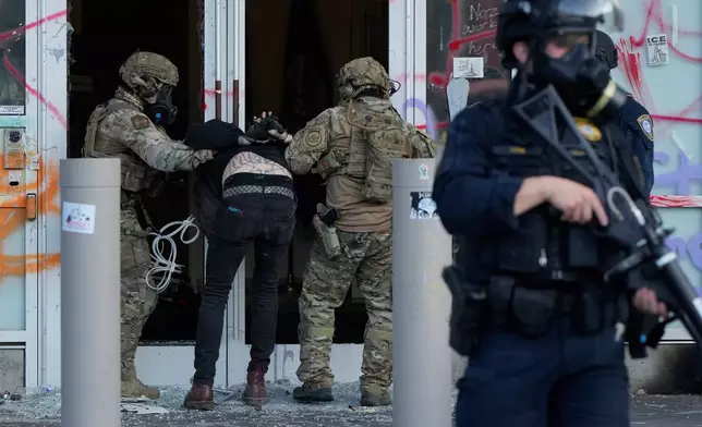 FILE - U.S. Customs and Border Protection agents detain a man outside the U.S. Immigration and Customs building during a protest in Portland, Ore., June 14, 2025. (AP Photo/Jenny Kane, File)