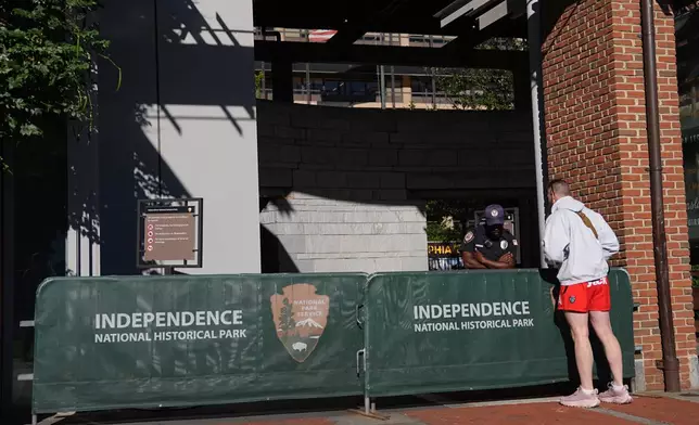 A man looks on in front of a barrier as Liberty Bell Center is closed due to a government shutdown, in Philadelphia, Wednesday, Oct. 1, 2025. (AP Photo/Matt Rourke)