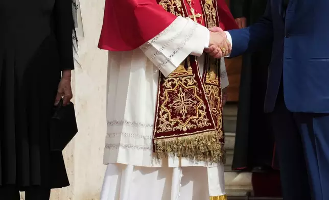 Pope Leo XIV, center, cheers with Britain's King Charles III and Queen Camilla in the St. Damasus Courtyard at the Vatican after a state visit and pray with him in the Sistine Chapel, Thursday, Oct. 23, 2025. (AP Photo/Andrew Medichini)