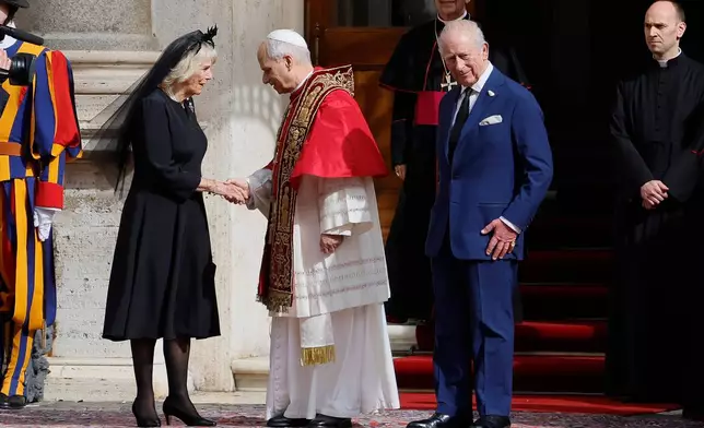 Pope Leo XIV, center, shakes hands with Britain's Queen Camilla as King Charles III looks on, in the St. Damasus Courtyard at the Vatican after a state visit and pray with him in the Sistine Chapel, Thursday, Oct. 23, 2025. (Cecilia Fabiano/LaPresse via AP)