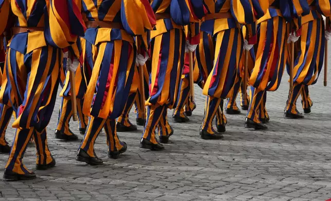 Swiss Guards march prior to the arrival of Britain's King Charles III and Queen Camilla arrive in the St. Damasus Courtyard at the Vatican for a state visit, where they will meet with Pope Leo XIV and pray with him in the Sistine Chapel, Thursday, Oct. 23, 2025. (AP Photo/Andrew Medichini)