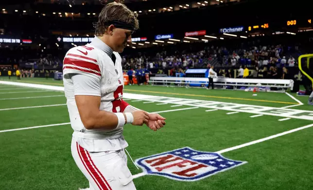 New York Giants quarterback Jaxson Dart walks off the field after a loss to the New Orleans Saints in an NFL football game, Sunday, Oct. 5, 2025, in New Orleans. (AP Photo/Butch Dill)