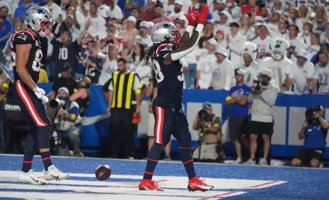 New England Patriots running back Rhamondre Stevenson, right, celebrates after his touchdown against the Buffalo Bills during the second half of an NFL football game, Sunday, Sept. 5, 2025, in Orchard Park, N.Y. (AP Photo/Gene J. Puskar)