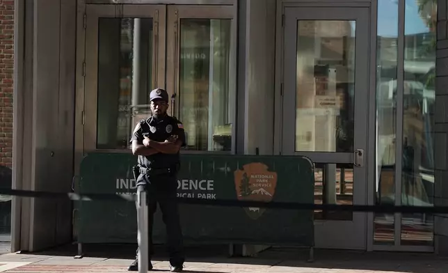 A guard stands at the entrance to The Liberty Bell center that is closed due to a government shutdown in Philadelphia, Wednesday, Oct. 1, 2025. (AP Photo/Matt Rourke)