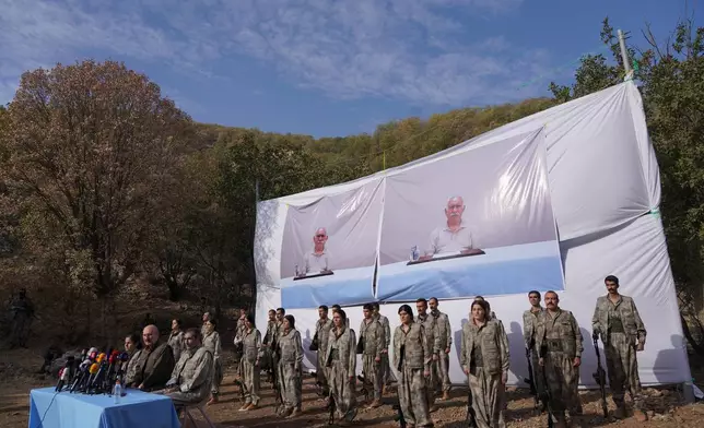Kurdistan Workers' Party (PKK) fighters, who reportedly withdrew from Turkey with their weapons, stand to attention during a ceremony in the Qandil area of northern, Iraq, Sunday, Oct 26, 2025. (AP Photo/Rashid Yahya)