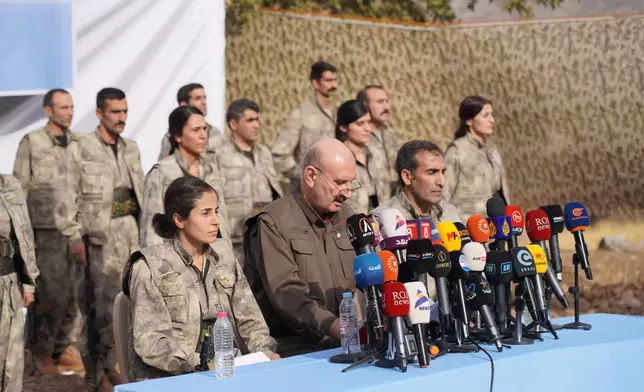 Kurdistan Workers' Party (PKK) fighters, who reportedly withdrew from Turkey with their weapons, stand to attention during a ceremony in the Qandil area of northern, Iraq, Sunday, Oct 26, 2025. (AP Photo/Rashid Yahya)
