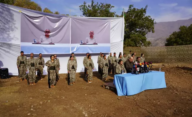 Kurdistan Workers' Party (PKK) fighters, who reportedly withdrew from Turkey with their weapons, stand to attention during a ceremony in the Qandil area of northern, Iraq, Sunday, Oct 26, 2025. (AP Photo/Rashid Yahya)
