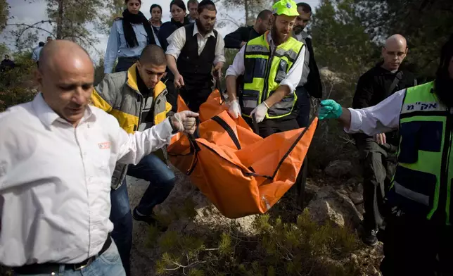 FILE - Israeli rescue workers carry the body of U.S. tourist Kristine Luken after she was found in a wooded area near the village of Mata, outside Jerusalem, Sunday, Dec. 19, 2010. (AP Photo/Tara Todras-Whitehill, File)