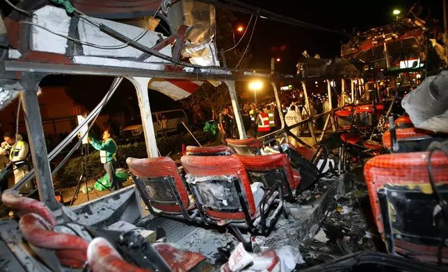 FILE - Police forensic officers work amid the remains of a bombed bus in the northern Israeli city of Haifa Wednesday, March 5, 2003. (AP Photo/Brennan Linsley, File)