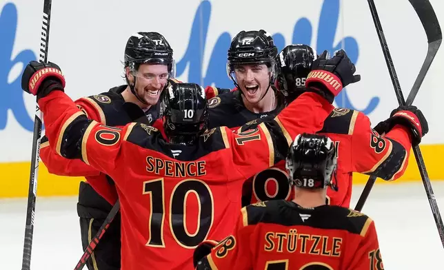 Ottawa Senators centre Shane Pinto (12)celebrates his game winning goal in a shootout with teammates centre Tim Stutzle (18), defenceman Jordan Spence (10) and defenceman Thomas Chabot (72) in NHL action against the Seattle Kraken in Ottawa, Thursday, Oct. 16, 2025. (Adrian Wyld/The Canadian Press via AP)