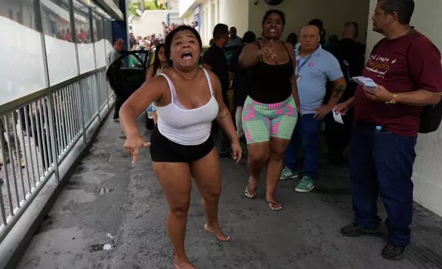 People protest outside Getulio Vargas Hospital shortly after their relatives were brought here by police due to injury during a police operation against alleged drug traffickers in the Complexo do Alemao favela where the criminal organization "Comando Vermelho" operates in Rio de Janeiro, Tuesday, Oct. 28, 2025. (AP Photo/Silvia Izquierdo)