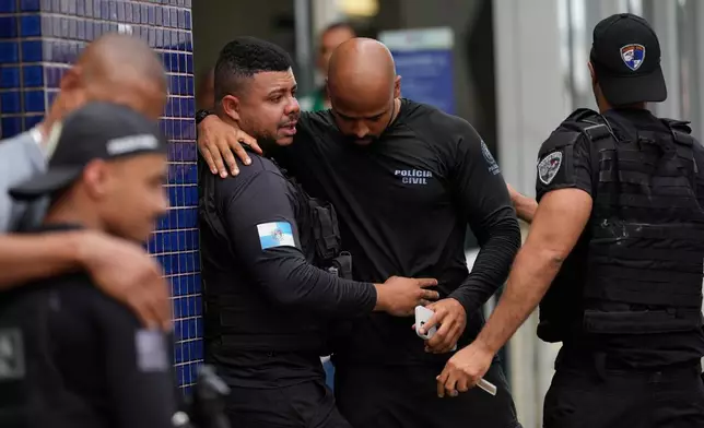 Police gather outside the Getulio Vargas Hospital where a colleague was brought after getting injured in an operation against alleged drug traffickers in the Complexo do Alemao favela where the criminal organization "Comando Vermelho" operates in Rio de Janeiro, Tuesday, Oct. 28, 2025. (AP Photo/Silvia Izquierdo)