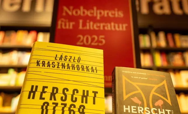 Books by Hungarian writer Laszlo Krasznahorkai are displayed in front of a stand with the inscription "Nobel Prize for Literature 2025" in Berlin's Dussmann cultural department store in Berlin, Germany, Thursday, Oct. 9, 2025. (Soeren Stache/dpa via AP)