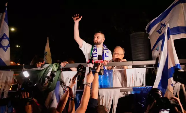 Freed Israeli hostage Matan Angrest, center, who was recently released from Hamas captivity in Gaza, greets supporters upon returning home to Kiryat Bialik, Israel, from the hospital, Thursday, Oct. 23, 2025. (AP Photo/Ohad Zwigenberg)