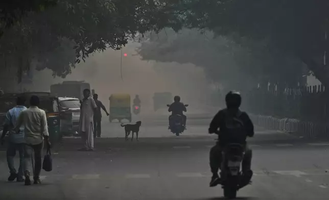 Commuters drive amidst morning smog in New Delhi, India, Tuesday, Oct. 21, 2025. (AP Photo/Manish Swarup)